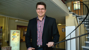 Mikko Ollikainen. Mikko Ollikainen står på en spiraltrappa i kommunkanslit i Vörå