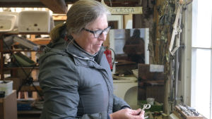Marianne Hemgård önskar att flera skulle utnyttja Curatios kunskap när gamla hus ska renoveras. Kvinna håller gammalt fönsterhandtag i handen.