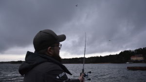 Kenny Andersson tycker det är betydligt intressantare att fiska med kastspö än med nät. Man står på brygga och fiskar med kastspö.