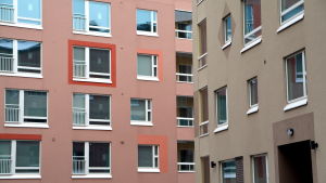 Tre skilda hus på en och samma bild. Stort byggnadsområde med färgfulla fasader.