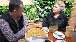 Den georgiske krögaren Zurab Guretjiani vill bekosta och ordna Jakovlevas åttioårsfest i januari. En man sitter vid resaturangbord med bröd framför sig