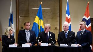 Fem nordiska försvarsministrar på rad: Danmarks Trine Bramsen, Finlands Antti Kaikkonen, Sveriges Peter Hultqvist, Islands Arnór Sigurjónsson och Norges Frank Bakke-Jensen. Fem försvarsministrar på rad vid ett podium: Danmarsk Trine Bramsen, Finlands Antti Kaikkonen, Sveriges Peter Hultqvist, Islands Arnór Sigurjónsson och Norges Frank Bakke-Jensen.