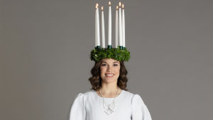 Lucia 2019, Sara Ray. Finlands lucia 2019 Sara Ray med krona med tända ljus och vit särk med rött band.