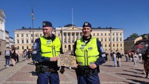 Janne Korhonen, till vänster var glad att få övervaka den antirasistiska manifestationen. Två poliser står med ett plakat med antirasistiskt budskap.
