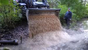 I fjol gick det åt 180 ton grus till att bygga lekplatser åt öringen. En traktor häller grus i en å för att öringen ska kunna leka där.