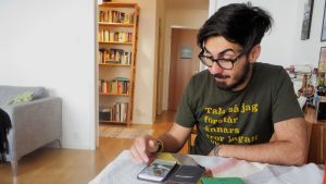 Adrian har nu vunnit två pris för sin poesi - själv är han förvånad då han inte trodde att han kunde skriva dikter. Adrian Perera sitter vid sitt bord.