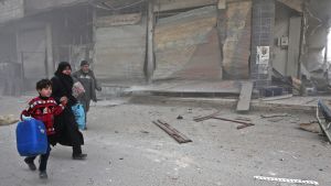 Kvinna med barn söker skydd undan bombardemang i östra Ghouta 
