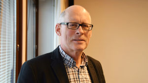 Henrik Ekblom är vd för Karis Telefon. En bild på en man i skjorta och kavaj som står i sitt kontor. Han har glasögon. Mannen heter Henrik Ekblom.