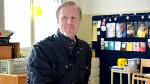 Magnus Törrönen har själv ätit morgonmål i det här rummet i daghemmet Petter. Det var på 1980-talet. Nu vill han ge sina barn samma möjlighet till den här svenska miljön i hjärtat av Virkby. En man med blont kort hår och mörkblå jacka sitter på en stol vid ett bord som är anpassat för små barn. Han är inne i ett daghem.