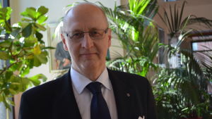 Omsorgsdirektör Juha Metso tror att de nya färdtjänstdirektiven kommer att godkännas på torsdagen. En äldre man står framför en krukväxt inomhus. Han ler och ser in i kameran.