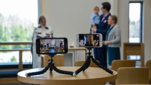 Alane Helena blev filmstjärna redan vid dopet. Två mobiltelefoner står på små stativ och filmar dopet.