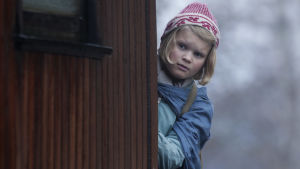 Vad säger de? Gerda (Anna Sofie Skarholt) litar inte längre på sin brors omdöme. Gerda (Anna Sofie Skarholt) kikar fram bakom ett hörn.