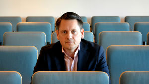 Markus Norrgård Markus Norrgård, ansvarig professor för Helsingfors universitets juridiska fakultet i Vasa, sitter mitt i ett auditorium och ser rakt in i kameran.