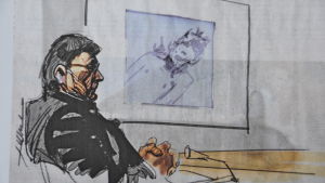 Gustafsson ser för första gången bilder av offren som projiceras på väggen. Här tittar den åtalade på en bild av sin mördade, före detta flickvän, som Lukkarinen valt att skissa grovt och utan detaljer i sin teckning. Teckninen är en fotokopia av originalet. Illustratören Hannu Lukkarinens teckning av mordmisstänkte Nils Gustafsson som tittar på en bild av sin mördade ex. flickvän.