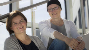 Silja Sahlgren-Fodstad och Johanna Grönqvist inväntar intresserat dina frågor. Silja och Johanna poserar i Yles trappa.