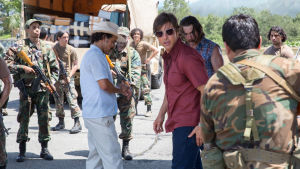 Hett om öronen. Barry Seal (Tom Cruise) inser ganska snabbt att det inte är helt omkomplicerat att smuggla vapen och droger. Barry Seal omgiven av beväpnade soldater.