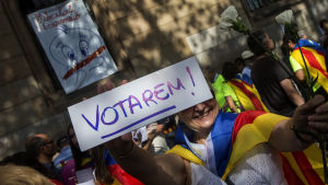 Kvinna håller plakat med texten "Vi tänker rösta" i Barcelona den 24.9.2017. Kvinna håller plakat med texten "Vi tänker rösta" i Barcelona den 24.9.2017.