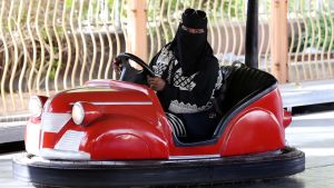 En kvinna kör en krockbil i en nöjespark i Riyadh i Saudiarabien.