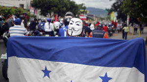 Demonstration i Tegucigalpa. Demonstration i Tegucigalpa. Folk marscherar i en lång rad med flaggor.