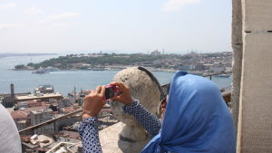 Det finns många saker att se i Istanbul. Yta och djup. Kvinna fotograferar från Galatatornet