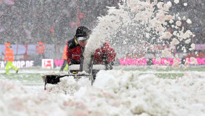 Snöröjning på fotbollsplan i Köln. Personal vid fotbollsarenan i Köln röjer snö från planen.