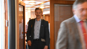 De första diskussionerna mellan Vasa och Korsholm hölls på Replot i december. Hans Frantz (SFP) från Vasa i förgrunden och Michael Luther (SFP) från Korsholm. Michael Luther (SFP) kommer ut från ett mötesrum.