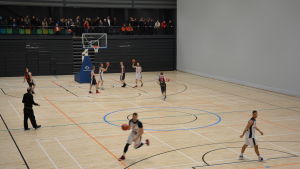 NMKY:s herrlag i basket tränar framför åskådare i bollhallen på onsdagskvällen. Män tränar basket inomhus i bollhallen i Åbo.