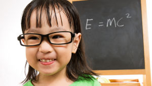 Relativitetsteorin Asiatisk liten flicka framför skoltavla med Einsteins formel för relativitetsteorin E = MC2