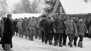 Iscensatt bild ur dokumentären Tammisunnuntai 1918. Soldater marscherar på en snöig väg. Iscensatt scen för dokumentären.