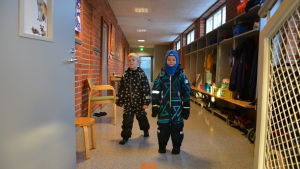 De svenska enheterna förfogar tillsammans över en egen korridor med tre rum. Barn med ytterkläder på i en skolkorridor.