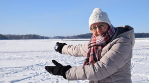 Minna Ermala är turistchef på Lojo stad. Här visar hon upp den stora iskarusellen. En kvinna står vid en snöklädd och isklädd sjö.