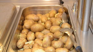 Potatisen har också tillretts i en ugn inann den sätts ut på serveringsbordet. Potatis som skolmat.