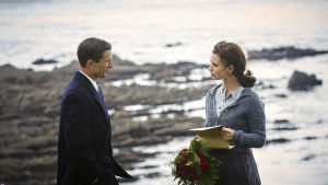 Tio tusen röda rosor. Fästmannen Mark (Glen Powell) förser ständigt Juliet (Lily James) med fräscha blommor. Juliet och fästmannen Mark på stranden.
