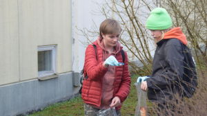 Okko Mäkipää och Jonne Marttila hittar både ett och annat. två pojkar med plastpåsar