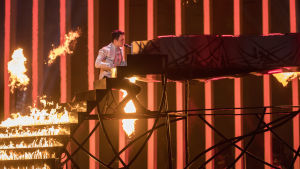 Ukrainska Mélovin framförde sin låt på Eurovision Song Contest år 2018. Man spelar på brinnande flygel