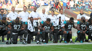 Spelare i Miami Dolphins knäböjer i protest. Knästående spelare