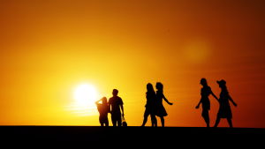Solen är en källa till D-vitamin som vi i Finland inte alltid har tillgång till. Människosilhuetter mot solnedgång