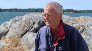 Ingmar Stranberg har rört sig på Östersjön i över 60 år. Äldre man står på ett berg i skärgården