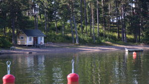 Motionsparken byggs nära stranden. En simstrand med en liten gul stuga. I förgrunden syns röda bojar.