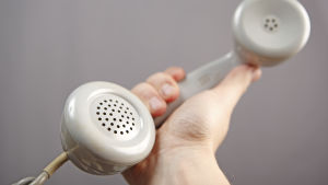 Vi är ofta rädda för nya element i vardagen som inte fanns i vår egen barndom. En hand håller i en vit telefonlur.
