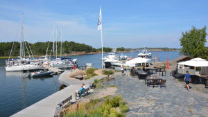 Örö öppnades för publik för fyra år sedan. Segelbåtar i Örö gästhamn, och kafégäster i hamnen.