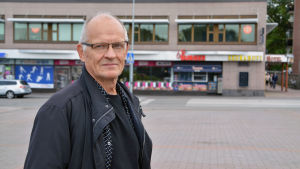 Förutom Mannerheimgatans bro är Löytönen också missnöjd med hur Borgå centrum ser ut för tillfället. Han säger att byggnaderna som syns i bakgrunden påminner om 70-talet. Eero Löytönen på Borgå torg.