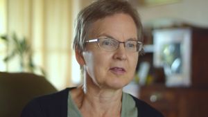 Siv Ekholm tycker inte det nya systemet fungerar. Kvinna med glasögon och kort hår sitter i en fotölj. I bakgrunden en grönväxt och ljusa garndiner.