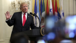 Trump meddelade att USA drar sig ur Parisavtalet. Donald Trump viftar med handen i en talarstol.