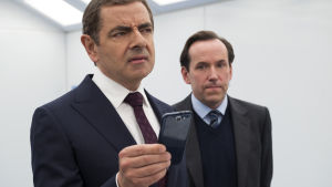 Vad är det här?! Säg den agent med självaktning som behöver detta moderna tekniktjafs? Jonny English och hans medarbetare Bough studerar med avsmak en mobiltelefon.