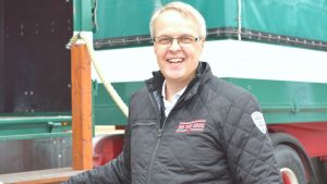 Sture Holm är projektarrangör för turnen. Man med glasögon som ler. en gammal lastbil i bakgrunden.
