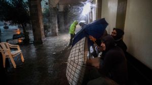 På många håll i Italien är flodbankerna dåligt underhållna vilket gör att floderna svämmar över Män söker skydd från stormen i Italien.