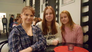 Fanny Konsin, Evelina Forsström och Adeline Uusimäki. Fanny Konsin, Evelina Forsström och Adeline Uusimäki sitter i en teaterlobby.