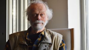 Kaj Björkqvist är professor i utvecklingspsykologi. Han efterlyser en lagändring för att ge djur en starkare juridisk ställning i samhället. En man i 60-årsåldern med grått hår och skägg sitter i en stol.