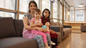 Zian Qader med döttrarna Yara och Lia. En mamma och två av hennes barn sitter i en soffa